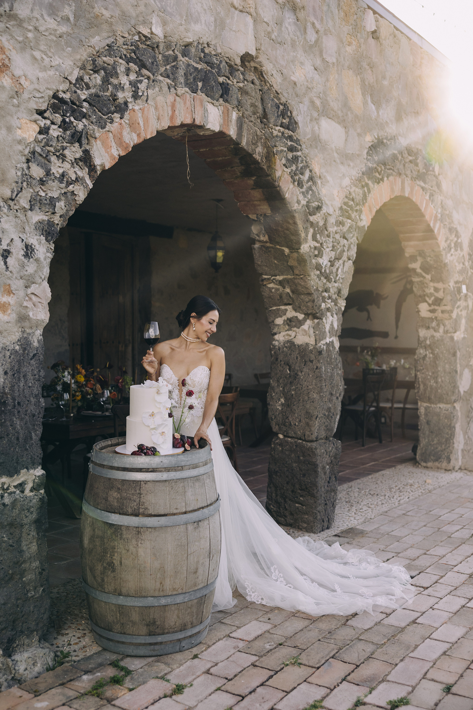 A bride beside her wedding cake at a stone venue