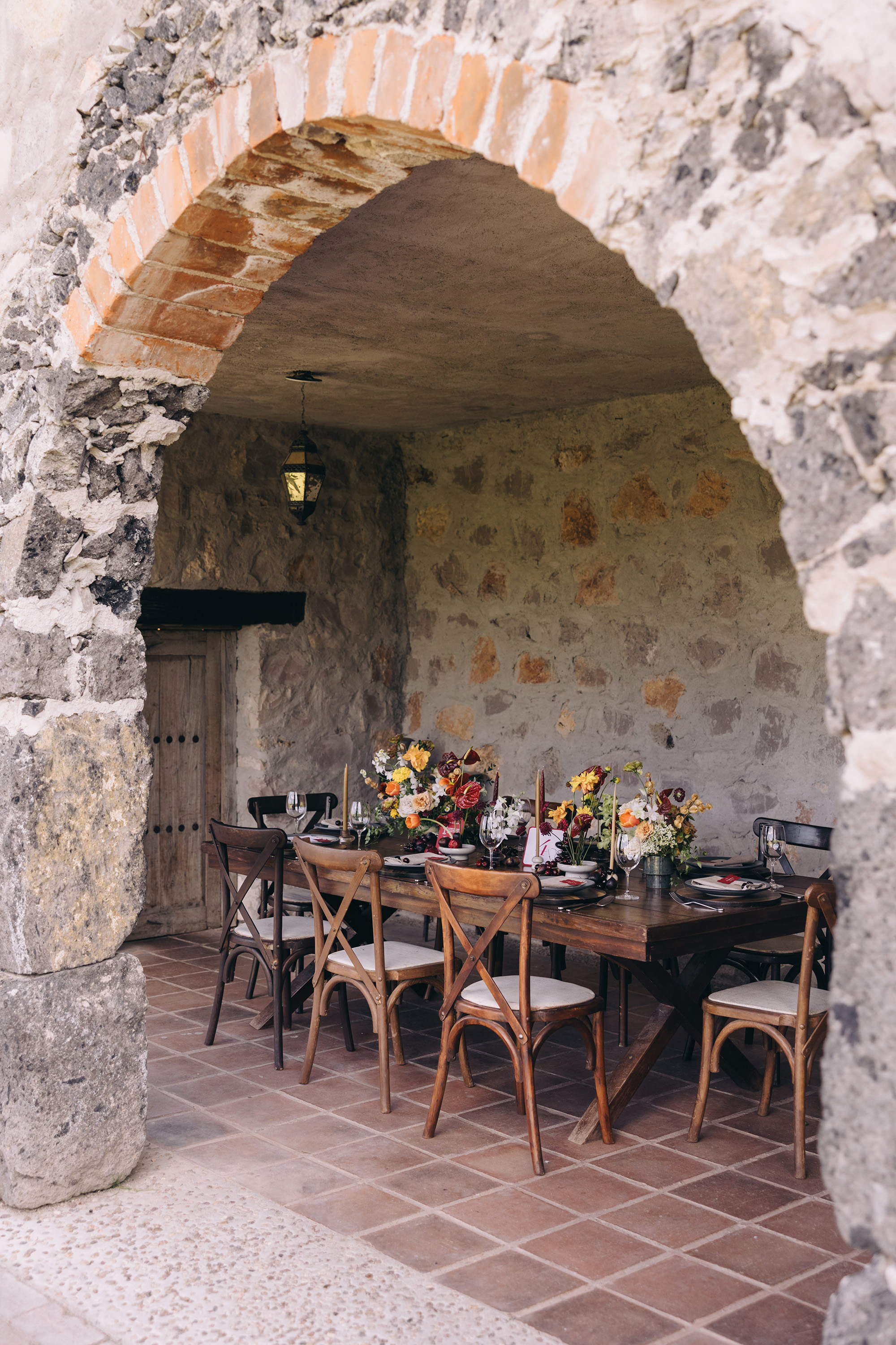 A styled wedding reception table beneath a floral arch