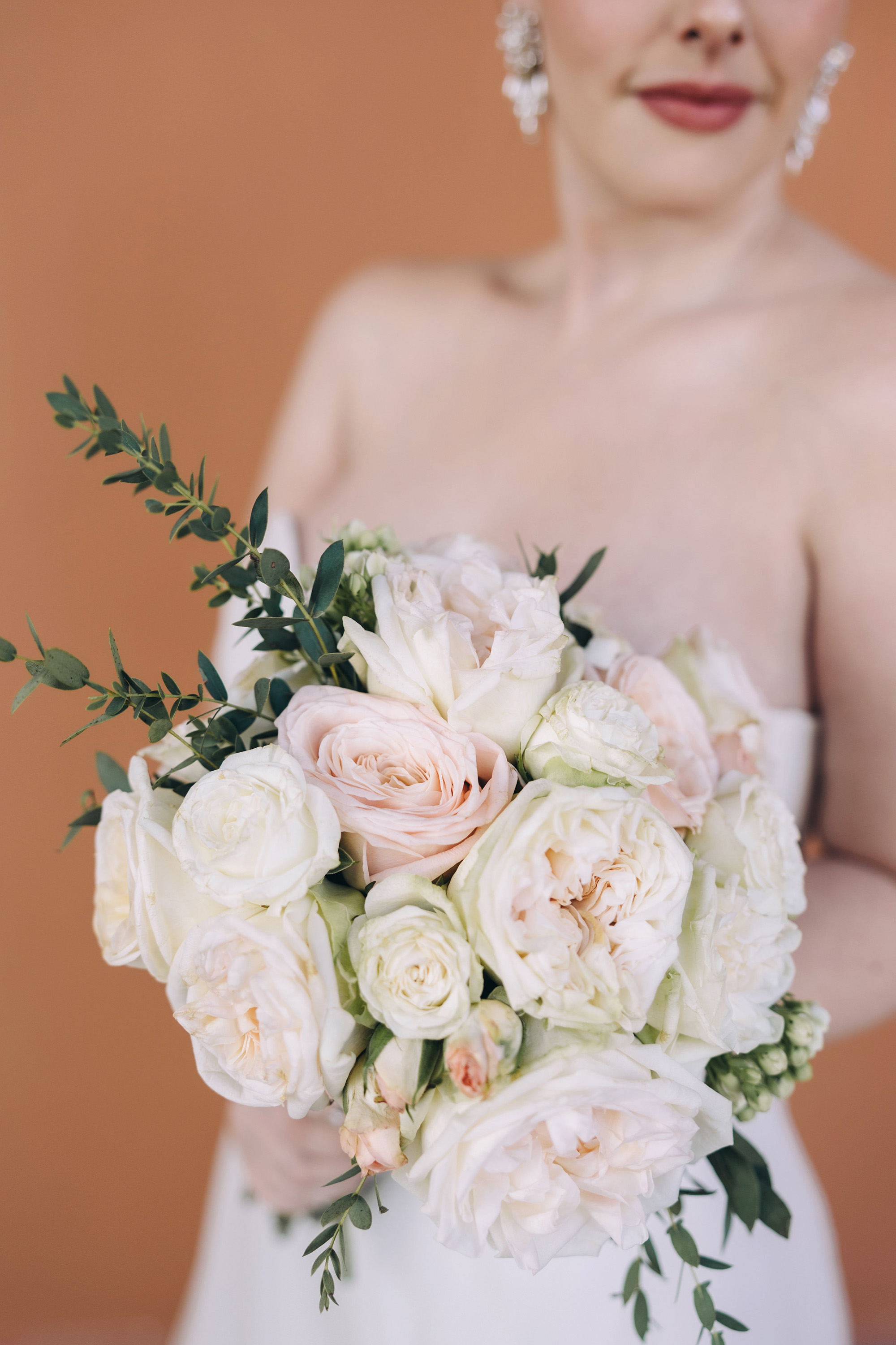 A bride holding a blush and ivory bouquet