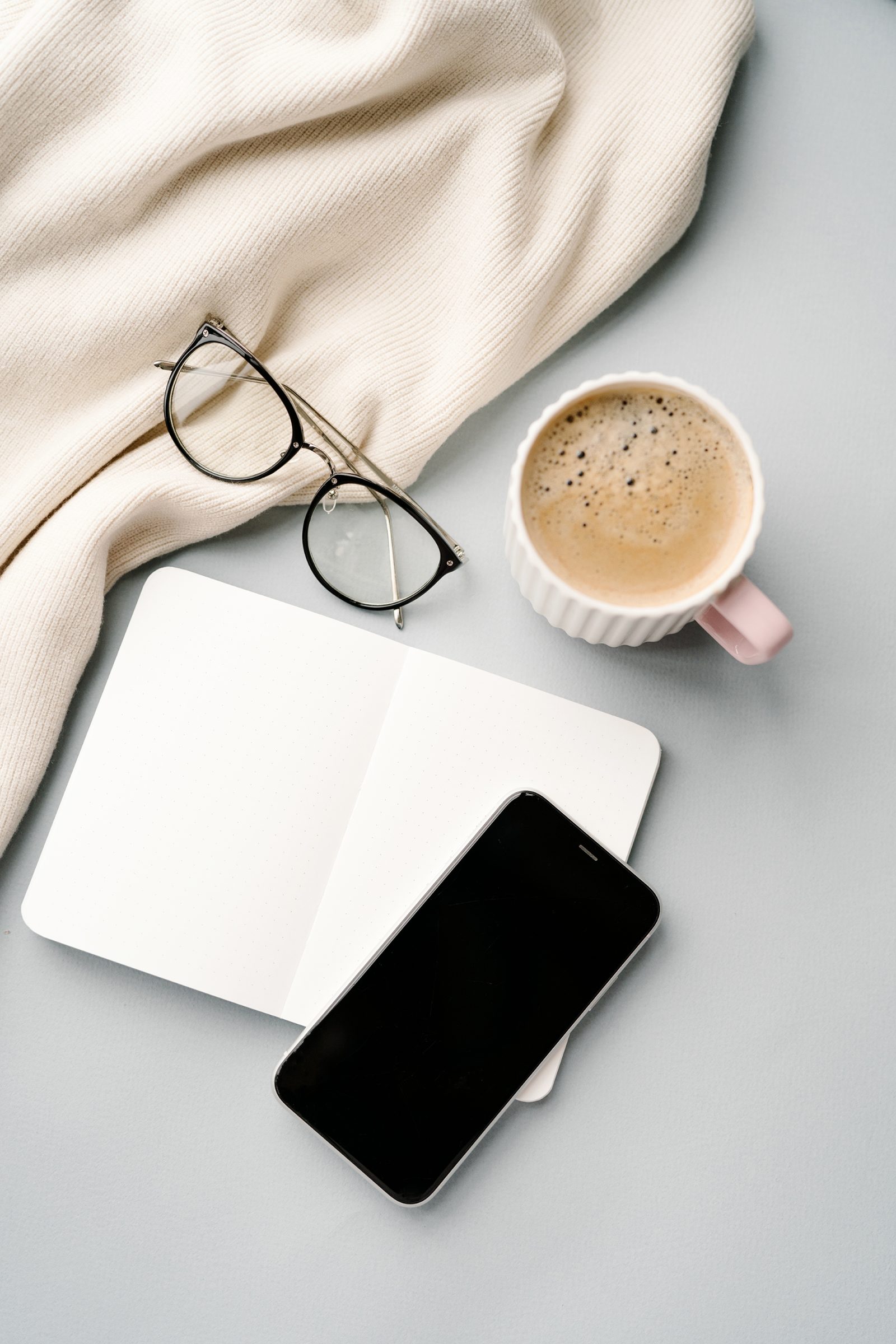 A notebook, coffee and phone flatlay